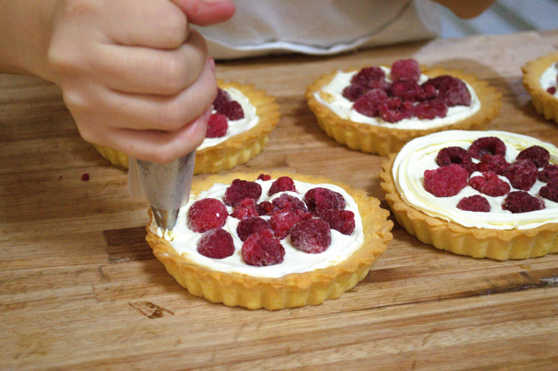 Tartaletas artesanales rellenas con crema y frutos rojos.