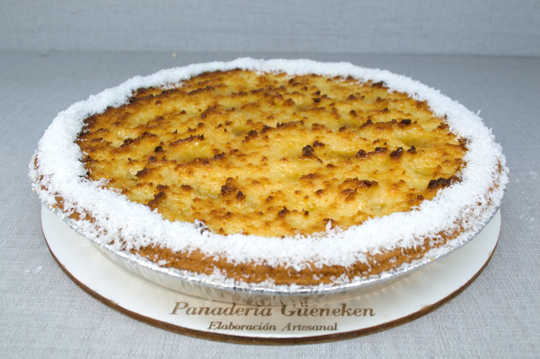 Tarta de coco dorada al horno con borde de coco rallado, Güeneken.