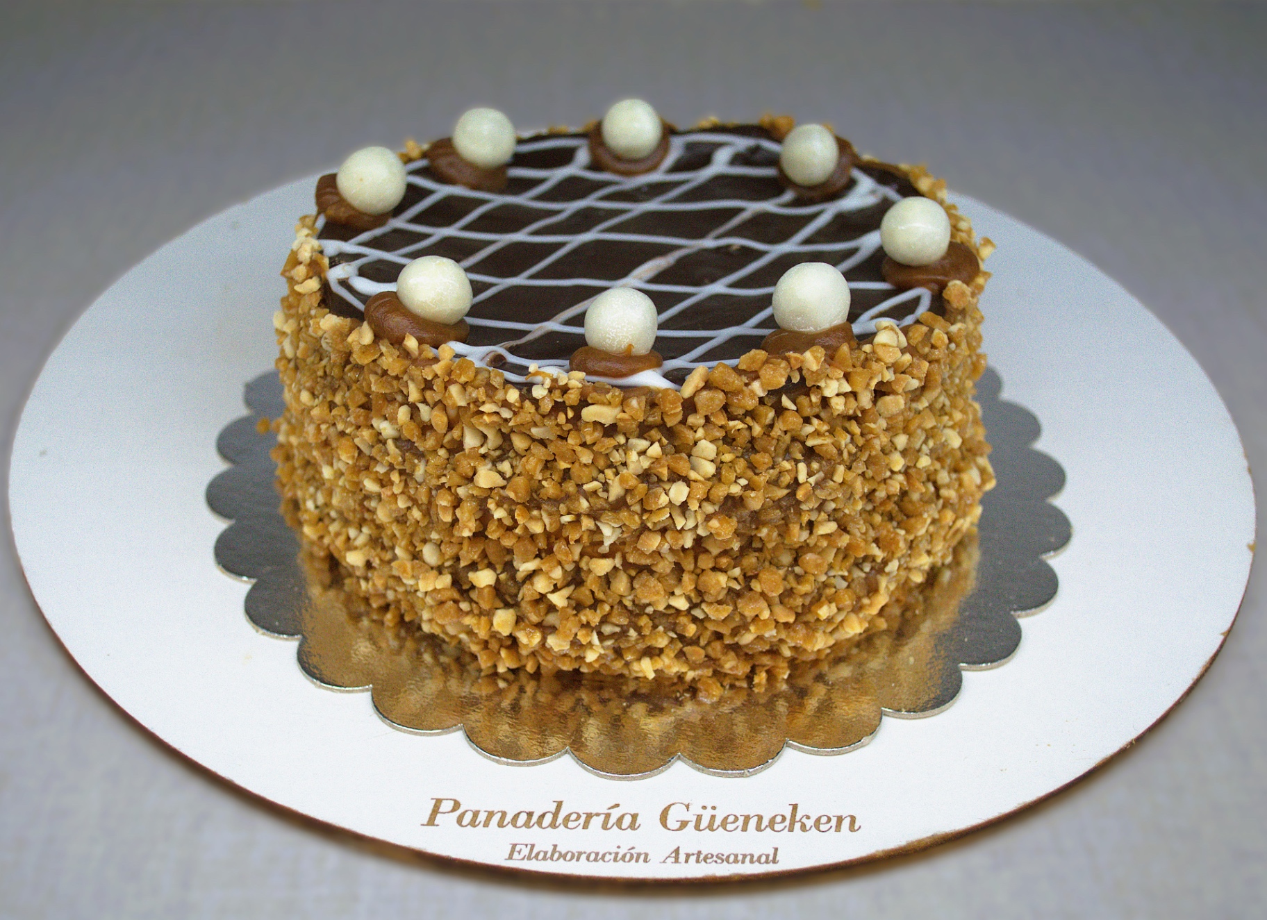 Torta milhojas con dulce de leche, maní y decoración de chocolate.